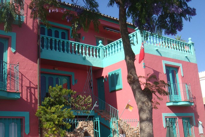 Pink and turquoise Andalusian building in Maro village, one of our properties